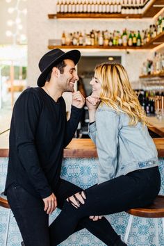 a man and woman sitting at a bar laughing