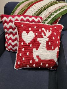 two crocheted christmas pillows on a couch