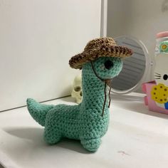 a crocheted stuffed animal with a hat on it's head sitting on a counter