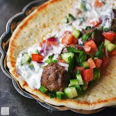 a pita with meatballs and vegetables on it