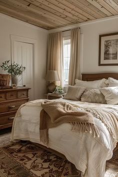 a bedroom with a bed, dresser and window in the corner is decorated in neutral tones