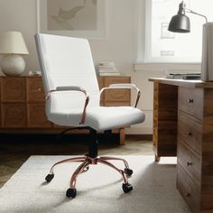 a white office chair sitting on top of a rug next to a wooden dresser and lamp