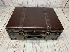 a brown leather suitcase sitting on top of a wooden floor