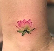 a small pink flower on the side of a woman's neck, with green leaves