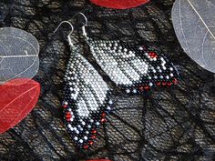 two pairs of beaded earrings with red, white and blue beads on black lace