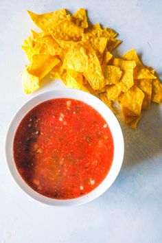 a bowl of salsa with tortilla chips on the side