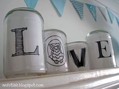 some jars are sitting on a shelf with the word love painted on them and an owl