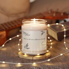 a candle sitting on top of a wooden table next to a string of lights and a guitar