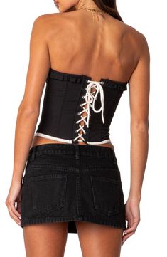 The sultry allure of a corset meets the laid-back comfort of a tube top in this ruffle-trimmed number framed by a front hook-and-eye placket and a lace-up back. Front hook-and-eye closure; lace-up closure Sweetheart neck Strapless 100% polyester Machine wash, dry flat Imported Summer Black Corset With Boned Bodice, Summer Black Boned Bodice Corset, Fitted Ruffled Strapless Tube Top, Fitted Strapless Ruffled Tube Top, Black Stretch Strapless Corset, Black Overbust Corset For Summer, Spring Club Corset With Boned Bodice, Black Ruffled Underbust Corset, Black Stretch Tube Top With Boned Bodice