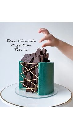 a hand reaching for chocolate cake on a plate with the words dark chocolate cake behind it