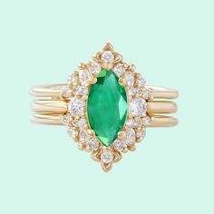 an emerald and diamond ring on a green background