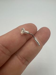 a person is holding a tiny silver ring