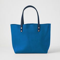 The Cerulean Cypress East West Tote is a large leather tote bag handmade in the USA with heirloom-quality craftsmanship and the very best materials. Cerulean Cypress is a thick and soft leather with a pillowy texture, even bright blue color, little to no pull-up, and pebbled grain. The Cerulean Cypress East West Tote comes standard with Navy handles. Blue Textured Leather Tote Shoulder Bag, Blue Everyday Shoulder Bag With Textured Leather, Blue Textured Leather Shoulder Bag For Everyday, Blue Textured Leather Everyday Shoulder Bag, Blue Leather Shoulder Bag With Rolled Handles, Blue Leather Bags With Smooth Grain, Blue Smooth Grain Shoulder Bag For Everyday Use, Blue Bags With Leather Lining For Everyday Use, Blue Smooth Grain Bag For Everyday Use