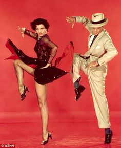 two people dressed in costumes and hats, one is dancing while the other holds his leg up