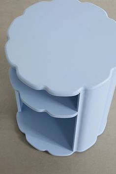 a white table with two shelves on top and one shelf in the middle for storage