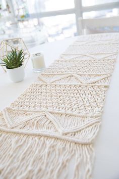 a white table with a crocheted runner on it