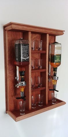 a wooden shelf with glasses and liquor bottles on it's sides, filled with shots