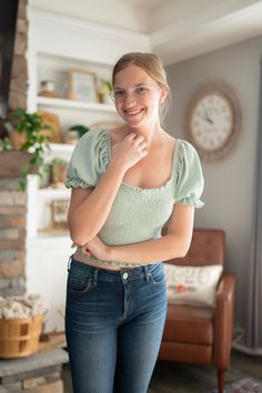 Make your mark with this Smocked & Smitten Over You Top! The sage-hued cotton gives you a winning combination of comfort and style, while the bubble cap sleeves add a touch of fun. Get ready to fall head over heels for this top - it's true-to-size and sure to turn heads! Stretch Smocked Top With Short Sleeves, Trendy Green Smocked Top, Casual Green Smocked Top With Puff Sleeves, Trendy Cotton Smocked Back Top, Casual Cotton Smocked Top With Short Sleeves, Trendy Cotton Smocked Top With Smocked Back, Trendy Stretch Smocked Top With Short Sleeves, Green Smocked Top With Short Sleeves For Summer, Green Fitted Smocked Top With Smocked Cuffs