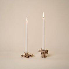 two white candles sitting next to each other