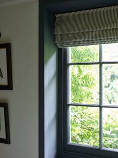 a window with blinds and pictures on the wall