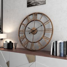 a clock sitting on top of a wooden shelf next to a book case and lamp