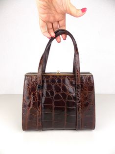 "Vintage 1950's 1960's structured handbag in brown animal leather and lined in rayon fabric.  Good vintage condition with minor wear. There is some wear to the hardware and on the handles. See detail photos. Measures 7\" high x 7 1/2\" wide; 3\" width at side; handle 4 1/2\" high" Vintage Brown Antique Bag For Formal Occasions, Antique Brown Bags For Formal Occasions, Antique Vintage Brown Formal Bag, Vintage Brown Formal Bag, Vintage Brown Rectangular Evening Bag, Retro Brown Formal Bags, Brown Formal Evening Bag With Top Carry Handle, Brown Tote Evening Bag With Top Carry Handle, Antique Style Vintage Brown Formal Bag