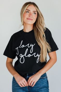 COMFORT COLORS All DU Exclusive items are excluded from all coupons and promotions Get ready for game day with the Glory Glory Script Tee! This comfy tee is designed with a soft and stretchy knit. It features a crew neckline, short sleeves, a relaxed fit, and the words "Glory Glory" on the front. Style the Glory Glory Script Tee with your fave denim and sneakers for a cute game day look! Comfort Colors Soft + Stretchy Knit Fabrication "Glory Glory" Graphic Crew Neckline Short Sleeves Relaxed Fit Black T-shirt With Letter Print For Game Day, Black School Spirit T-shirt With Slogan, Black Crew Neck T-shirt For School Spirit, Black Fan Apparel Top With Text Print, Trendy Black Tops With Lettering, Trendy Crew Neck Top For Game Day, Trendy Black Top With Lettering, Black Slogan Fan Apparel Top, Black Slogan Top Fan Apparel