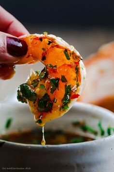 a person dipping some food into a bowl