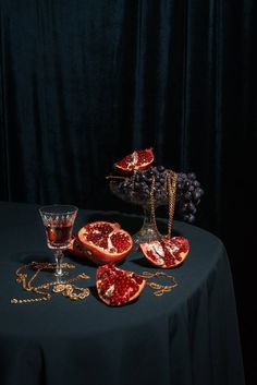 a table topped with cut up pomegranates next to a wine glass