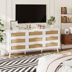 a living room with white furniture and a large flat screen tv mounted on the wall