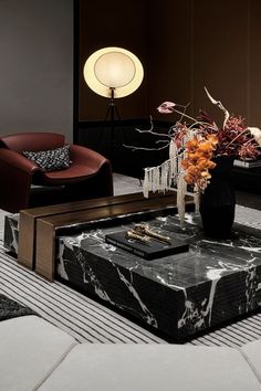 a modern living room with black marble coffee table and red leather chair in the background