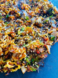 a blue plate topped with fried vegetables and seasoning sprinkled on top of it