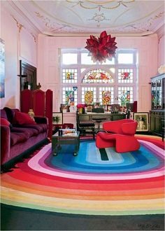 a living room filled with lots of furniture and colorful rugs on top of the floor