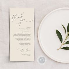 a white plate topped with a green leaf next to a thank card