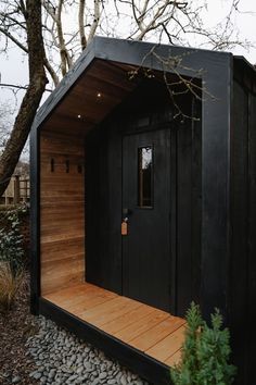 The porch area of a black-stained bespoke Heartwood sauna cabin in a private garden in Oxfordshire. Sauna Building, Working With People, Black Cabin, Tiny House Exterior, Backyard Plan