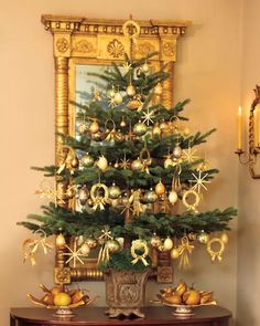 a small christmas tree with gold ornaments on it