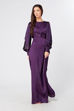 Description Composition Size This stylish purple maxi dress with wide long sleeves is a refreshing new addition to the ladies' wardrobe. The soft and lavish crepe fabric is very light and smooth. The wide skirt flows gracefully from the waist down to elongate the legs. And the top fits perfectly on the shoulders and gives a flawless accentuated upper body.  Shape: Fitted and Maxi Sleeves: Floating Long Sleeves. Purple Button Closure with Big Cuffs Colour: Purple Length: 60 inches or 152 cm (Our model is 168 cm and wearing a size S) Skirt Style: Flowy and Maxi Top Style: Knotted on front and button on back  Neckline: Closed neckline Pattern: Crepe  Zipper: Hidden Zipper Closes at The Side, Elasticated back Fabric: 95% Polyester, 3% Viscose, 2% Nylon. The fabric is very light and airy Occasi Flowy Long Sleeve Maxi Dress For Evening, Solid Long Sleeve Maxi Dress For Evening, Solid Color Long Sleeve Maxi Evening Dress, Dinner Maxi Dress With Draped Sleeves, Evening Maxi Dress With Gathered Bishop Sleeves, Evening Maxi Dress With Bishop Sleeves, Long Sleeve Purple Maxi Dress For Fall, Chic Purple Evening Maxi Dress, Elegant Purple Floor-length Maxi Dress