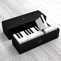 an open black box with white keys sitting on top of a wooden floor