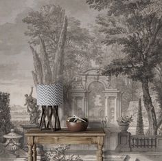 a table with a lamp on top of it next to a wallpapered mural