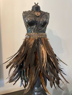 a mannequin is adorned with feathers and beads