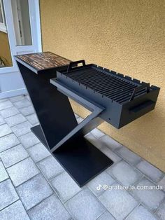 an outdoor bbq grill sitting on the side of a building next to a door