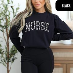 Camo Nurse Long-Sleeve - Gray & White Comfort Colors Top Grey and white camo nurse college font on a long-sleeve comfort colors shirt is the ultimate wardrobe staple for nurses and nursing students alike. This stylish shirt features a modern camo design in subtle grey and white tones, paired with bold college font that showcases your nursing pride. Crafted from soft and durable comfort colors material, this shirt is perfect for all-day wear. Whether you're attending classes, working long shifts, Long Sleeve Cotton Nursing Tops, Relaxed Fit Long Sleeve Nursing Top, Casual Long Sleeve Nursing Tops, Casual Long Sleeve Nursing T-shirt, Black Graphic Print Nursing Top, Black Nursing Top With Graphic Print, Fall Crew Neck Nursing Top, Relaxed Fit Nursing Tops With Crew Neck, Casual Black Nursing Top