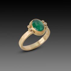 A luscious rose cut, oval emerald is wrapped in warm 22k gold and nestled between two diamond trios. Set on a hammered, 3mm 18k gold band. This ring would make a stunning engagement ring, or a special addition to your jewelry collection. Emerald measures approximately 3/8 inch x 7/16 inch. Matte finish. Oval Emerald Ring With Single Cut Diamonds, Oval Emerald Ring With Rose Cut Diamonds, Heirloom Oval Emerald Ring With Single Cut Diamonds, Oval Emerald Ring With Single Cut Diamonds For Anniversary, Oval Rose Cut Diamond Rings For May Birthstone, Heirloom Oval Emerald Ring With Rose Cut Diamonds, Oval Gold Emerald Ring With Rose Cut Diamonds, Oval Emerald Ring With Rose Cut Diamonds In Gold, Oval Emerald Ring With Rose Cut Diamonds For Anniversary