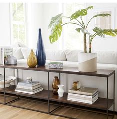 a living room with a couch, table and two vases on top of it