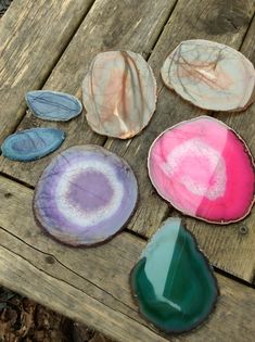 several different colored stones sitting on top of a wooden table