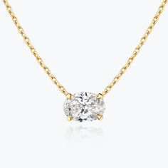 a gold necklace with a single diamond on the front and side, set against a white background