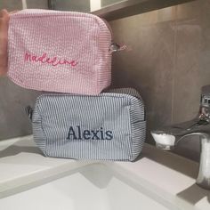 two personalized bags sitting on top of a sink