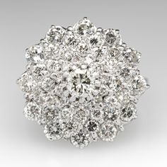 This sparkling circa 1974 English cluster cocktail ring is centered with one (1) prong set, round brilliant cut diamond. Surrounding the center are forty-eight (48) round brilliant cut diamonds that are all prong set. The ring measures 19.8mm at the top, rises 12.0mm above the finger, tapering to 1.8mm wide and 1.0mm thick at the base of the shank. The shank is stamped with London, England hallmarks. It is currently a size 8. Dazzling Cluster Diamond Ring With Brilliant Cut, Dazzling Diamond Cluster Ring With Single Cut Diamonds, Dazzling Cluster Diamond Ring With Single Cut Diamonds, Cluster Ring With Single Cut Diamonds In Cubic Zirconia, Cubic Zirconia Cluster Ring With Single Cut Diamonds, Dazzling Brilliant Cut Cluster Ring For Anniversary, Dazzling Brilliant Round Cut Cluster Ring, Classic Brilliant Cut Cluster Diamond Ring, Classic Cluster Diamond Ring With Brilliant Cut