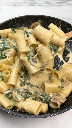 pasta with mushrooms and spinach in a skillet