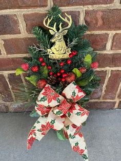 a christmas tree with red berries, green leaves and a deer head hanging on it